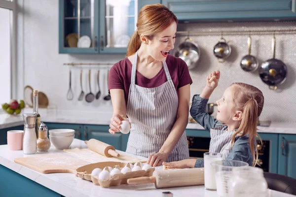 Kleines Mädchen und hilft ihrer Mutter beim Plätzchenbacken — Stockfoto