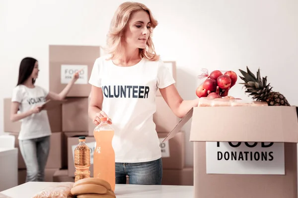 Blij vrouwelijke persoon liefdadigheid doos verpakking — Stockfoto