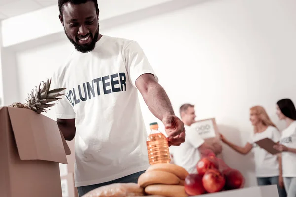 Восхитительный темнокожий мужчина собирает продукты — стоковое фото