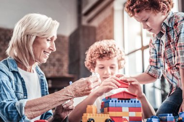 Onun torunları ile oynayan neşeli yaşlı kadın