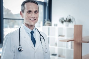 Ayakta ve gülümseyen sorumlu hoş doktor.