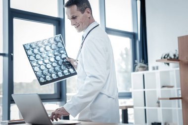 Ayakta ve x-ray tarama tutan kendine güvenen nitelikli doktor.