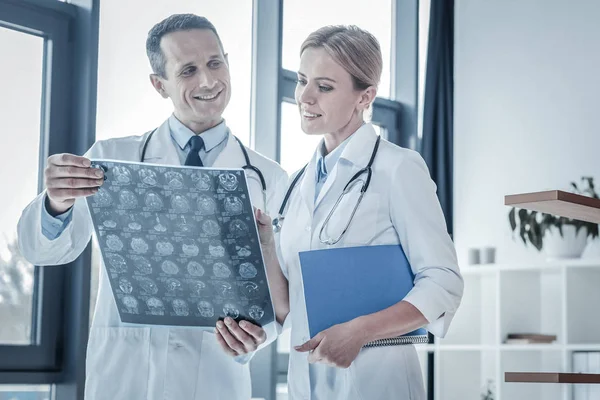 Interesse geschoolde arts permanent en kijken naar zijn collega. — Stockfoto