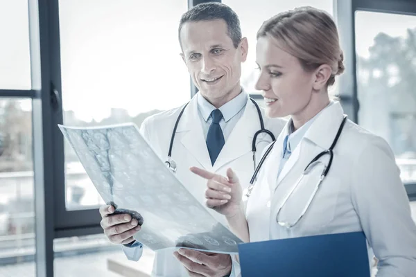 Interested responsible doctors examining the x-ray scan focusing on it. — Stock Photo, Image