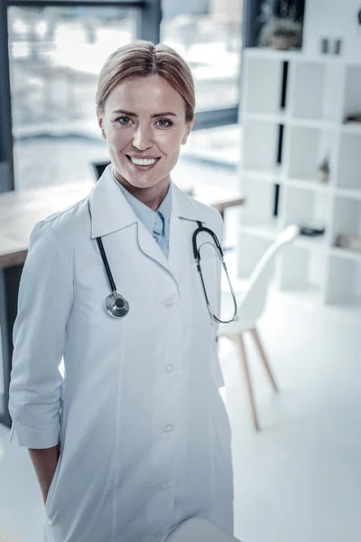 Enfermeira confiante bonito de pé e sorrindo . — Fotografia de Stock