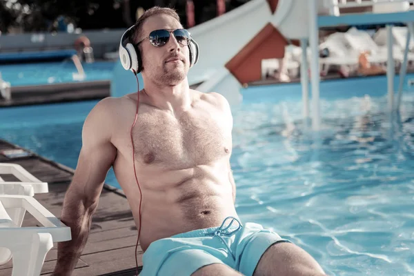 Relaxado homem apto banho de sol e ouvir música — Fotografia de Stock