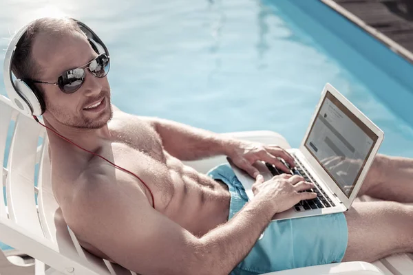 Positive minded man smiling while working and sunbathing — Stock Photo, Image