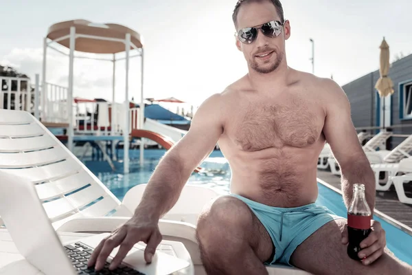 Sportif yakışıklı üstünde laptop yüzme havuzunda çalışma — Stok fotoğraf