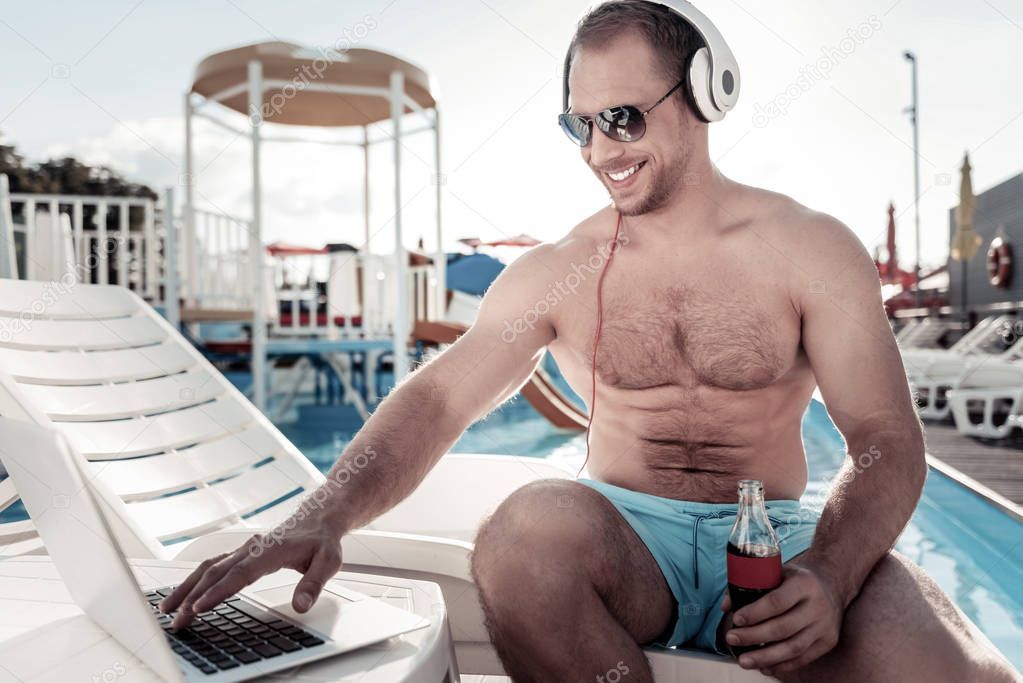 Joyful guy smiling while working at swimming pool