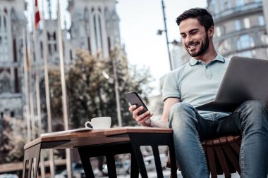 Başarılı bin yıllık adam açık havada çalışırken gülümseyen