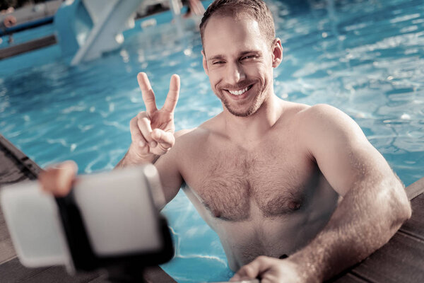Young man gesturing while posing for self portrait picture