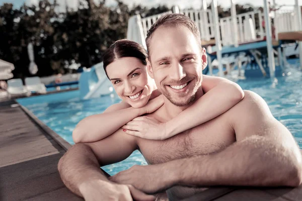 Beaming couple relaxing and swimming in pool — Stock Photo, Image