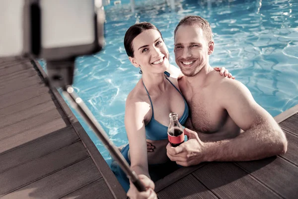Cheerful couple posing for selfie in swimming pool — Stock Photo, Image