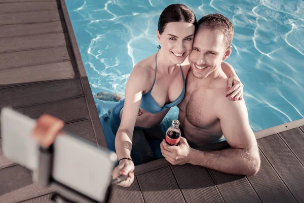 Top view on relaxed couple taking selfies in swimming pool — Stock Photo, Image