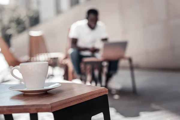African american człowiek działa na laptopie w lokalnej kawiarni — Zdjęcie stockowe