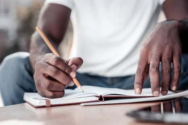 Close up of african american man taking notes — Stock Photo, Image