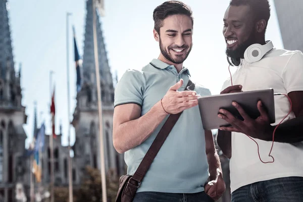 Smiling mates compartilhamento de vídeo no computador tablet ao ar livre — Fotografia de Stock