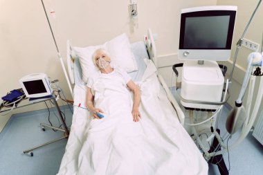 Senior woman undergoing treatment at hospital clipart