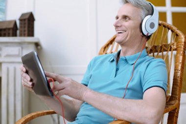 Neşeli yaşlı adam bir tablet holding