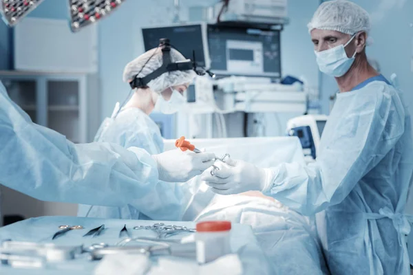 Médico serio y confiado de pie y tomando el instrumento . — Foto de Stock