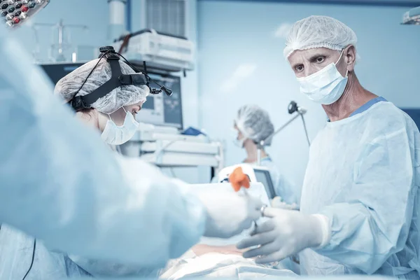 Médecin occupé concentré prenant l'instrument et opérant . — Photo