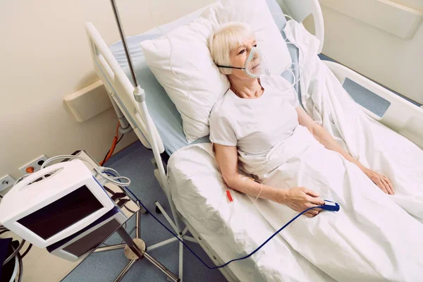 Mujer enferma con equipo médico de frecuencia cardíaca y soporte respiratorio — Foto de Stock