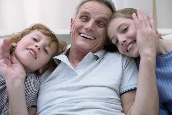 Счастливый старик общается с внуками — стоковое фото