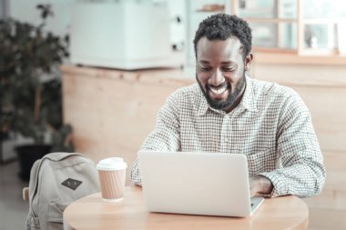 Onun netbook kullanan neşeli pozitif adam