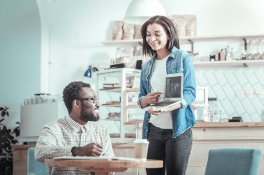 Netbook ekrana işaret eden güzel memnun kadın