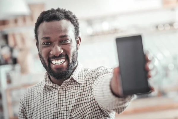 Šťastlivec pozitivní ukazující jeho smartphone — Stock fotografie