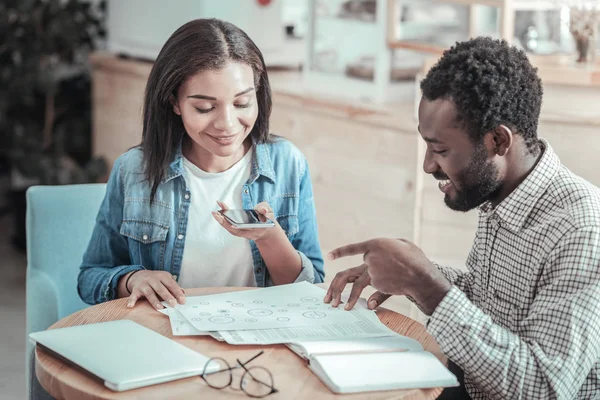 Mujer joven agradable mirando sus notas — Foto de Stock