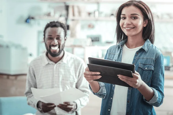 Mujer joven positiva sosteniendo una tableta — Foto de Stock