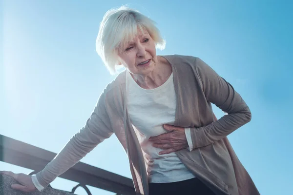 Испуганная пожилая женщина, страдающая от сердечного приступа — стоковое фото