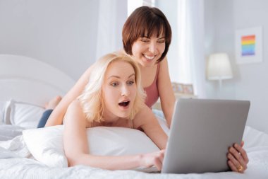 Bir dizüstü bilgisayar kullanarak neşeli pozitif kadın