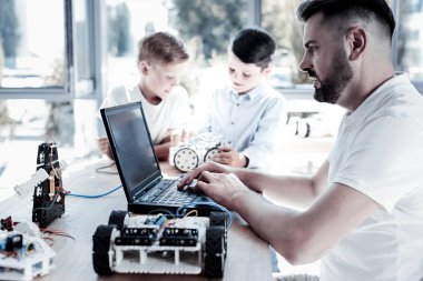 Olgun erkek öğrencilerin atölye yanında laptop çalışma