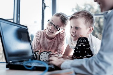 Meraklı çocuklar robotlar üzerinde çalışırken laptop arıyorum