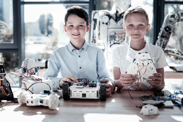 Joyful amigos do sexo masculino construindo máquinas robóticas — Fotografia de Stock