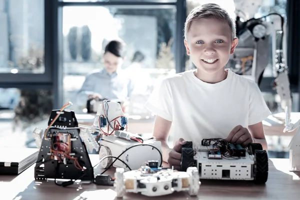 Uiterst gelukkig kind stralend tijdens het werken aan technologische project — Stockfoto