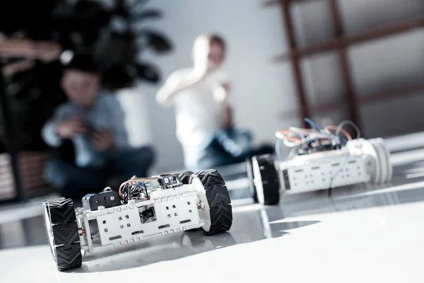 Close up on robot with wheels driven by schoolboys — Stock Photo, Image