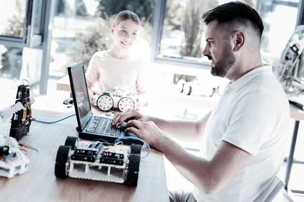 Serious teacher programming robot of his student — Stock Photo, Image