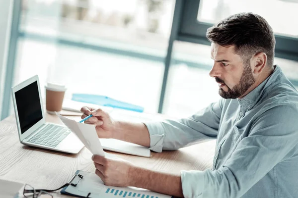 Uomo serio che controlla i dati nel documento — Foto Stock