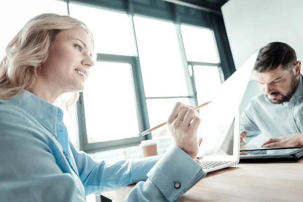 Ernstige kantoormedewerker zittend op de achtergrond — Stockfoto