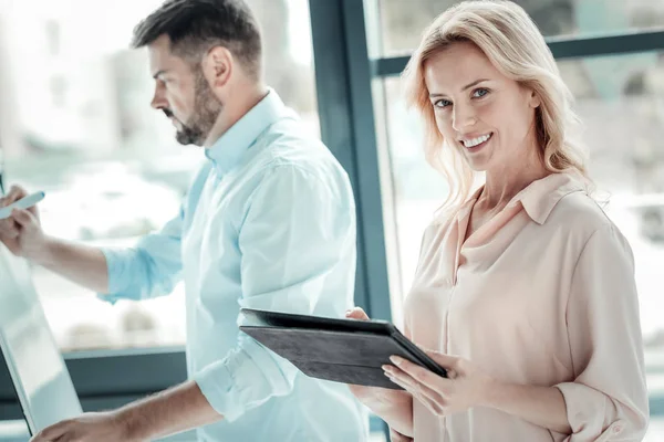 Rubia alegre manteniendo sonrisa en su cara — Foto de Stock