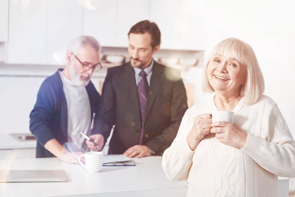 Share Your Hospitality Cheerful Delighted Aged Woman Drinking Tea While — Stock Photo, Image