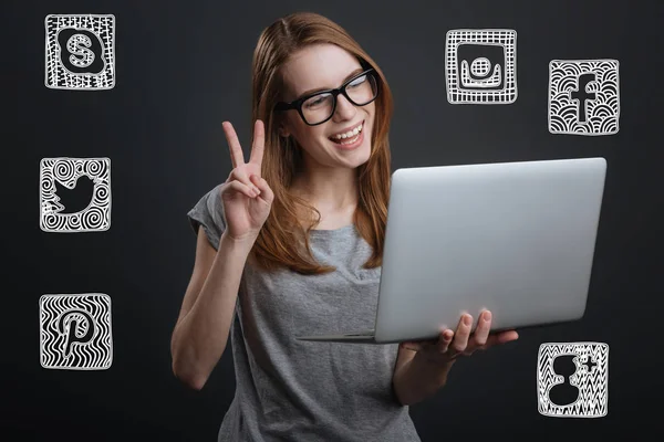 Chica feliz mostrando un signo de paz mientras se comunica en línea — Foto de Stock