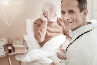 Oturma ve gülümseyen hoş emin doktor.