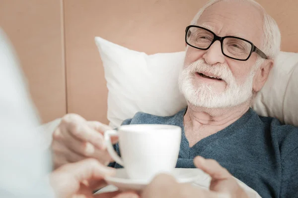 Freudiger älterer Mann liegt und lächelt. — Stockfoto