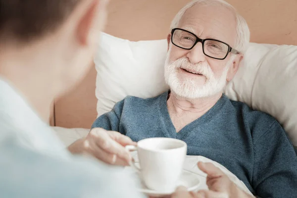 Piacevole uomo intelligente che prende una tazza e sorride . — Foto Stock