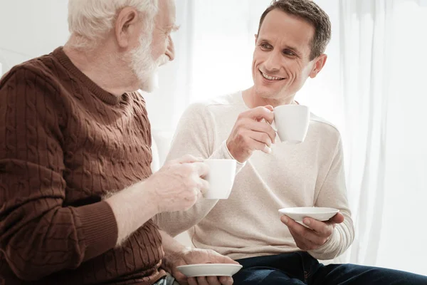 Intéressé homme attentif tenant une tasse et écoutant . — Photo