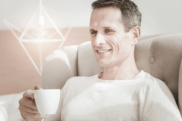 Satisfecho hombre tranquilo sentado y tomando té . — Foto de Stock